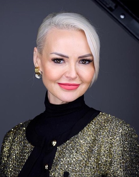 Woman with blonde hair smiling in professional attire.