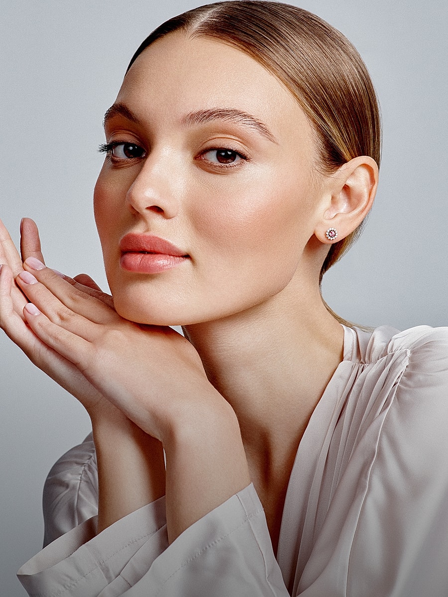 Model showcasing elegant earrings and soft makeup.