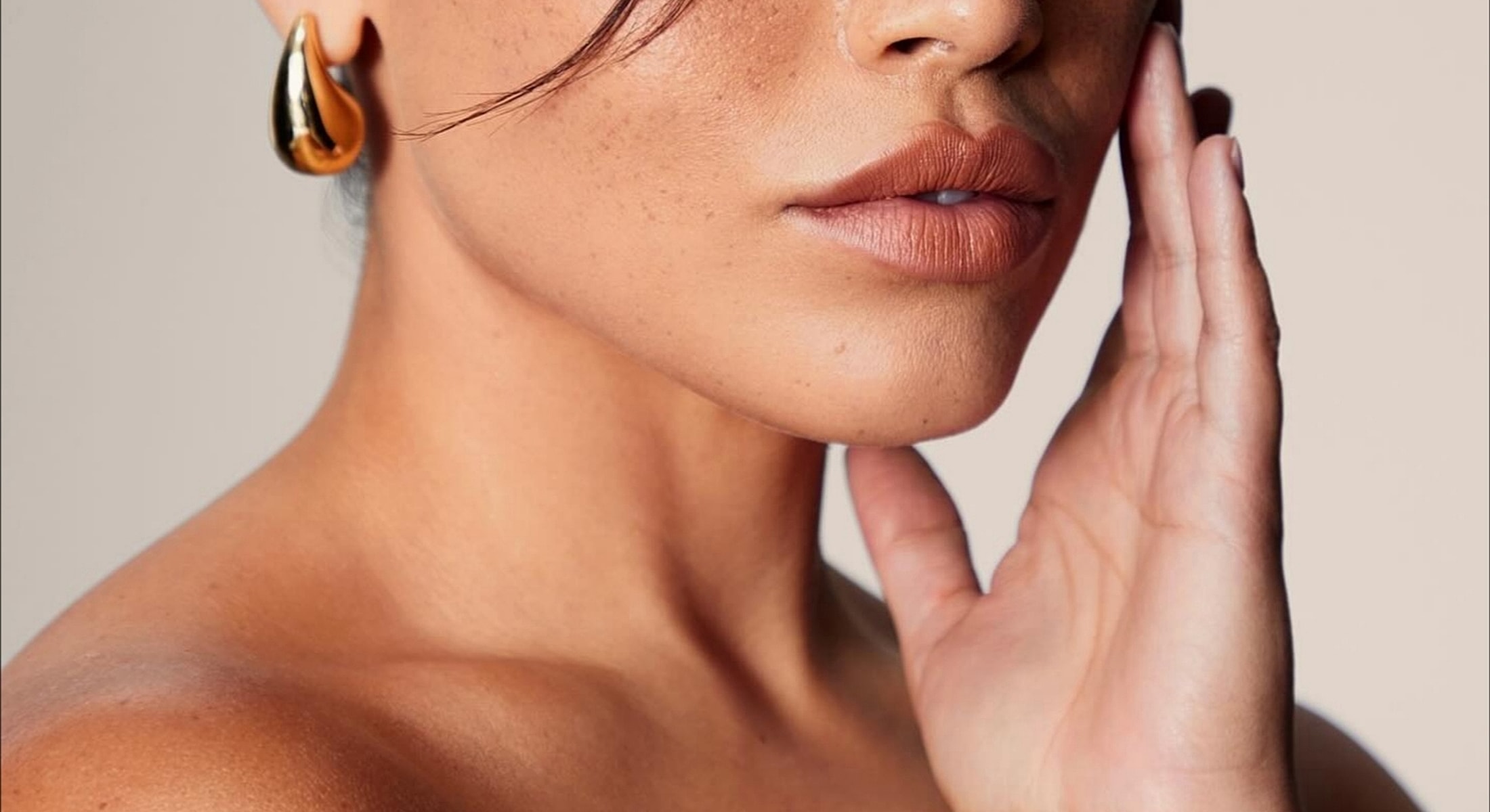 Close-up of woman touching her face.